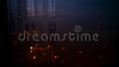 随着城市灯光模糊的背景，雨季<strong>玻璃窗</strong>户上的<strong>雨滴</strong>被关闭。 概念